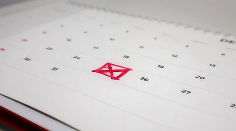 A close-up of a calendar page with the number 25 crossed out with a red mar.. Stock Photos
