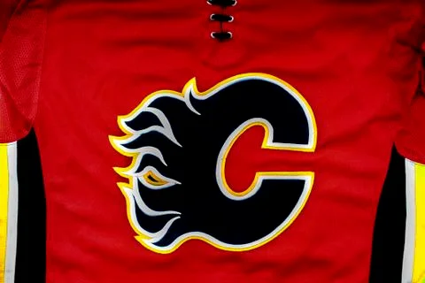 A close up to a Calgary Flames logo on a Red hockey jersey. Stock Photos