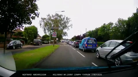 Close call during UK driving lesson as red car pulls out in front of learner Stock Footage 273013754