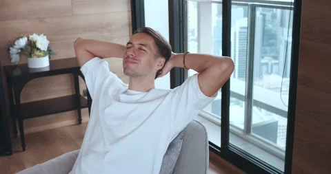 Close up calm man relax lean in comfy armchair with closed eyes and put hands Stock Footage 256915614