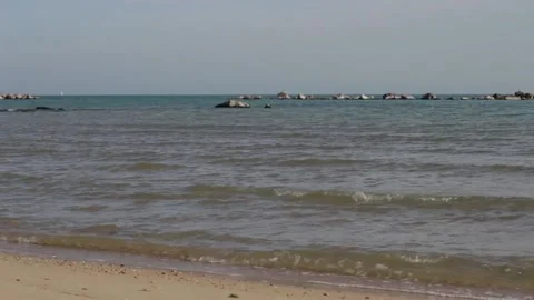 Close-up of calm sea waves. In the background the rocks. A relaxing day Stock-Footage 239309968
