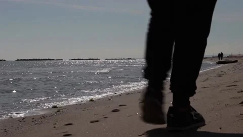 Close-up of calm sea waves. In the background the rocks and people taking Stock Footage 239311238