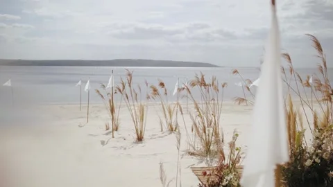 Close-up of calm white flag on the beach as a part of wedding deco, sea on the Stock Footage 308451026