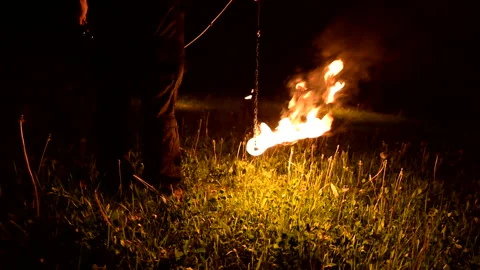 Close-up. Camera follows man in the dark with a burning ball, poi. Fire show Stock Footage 121744345