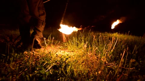 Close-up. Camera follows man in the dark with a burning ball, poi. Fire show Stock Footage 123731492