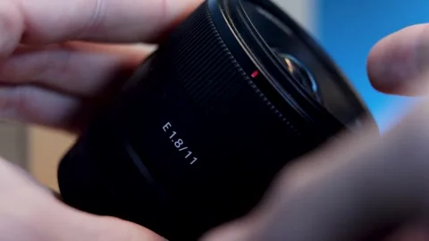 Close-up of a camera lens held by a person, highlighting its intricate design Video stock 297768621