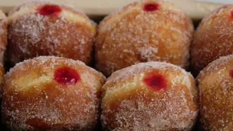 Close-up camera movement. Berliners. Donuts with raspberry jam lie on a serving Video stock 146867856