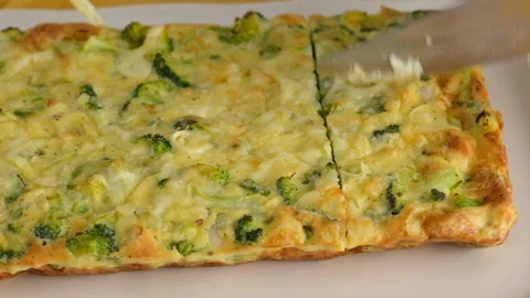 Close-up camera movement. Female hands cut frittata with broccoli on the plate Video stock 146923064