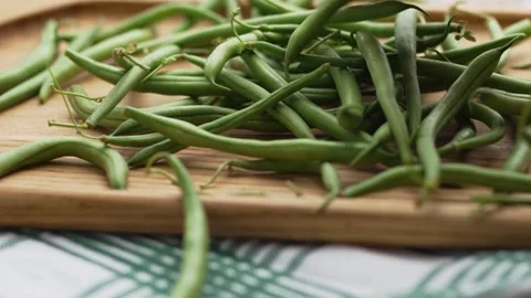 Close-up camera movement over organic raw green beans on a wooden surface Stock Footage 343555566
