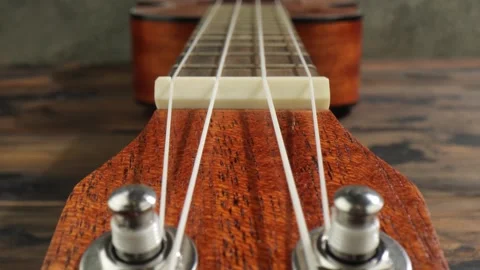 Close up camera movement over wooden ukulele fretboard and tuning pegs of t.. Stock Footage 337344503