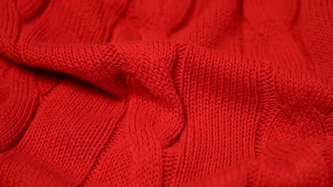 Close-up of the camera movement on a red knitted cotton fabric of a knitted plai Stock Footage 122246399