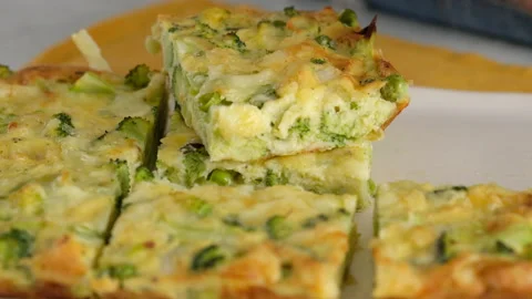 Close-up camera movement. Women's hands place a slice of broccoli frittats on a Stock Footage 146923242