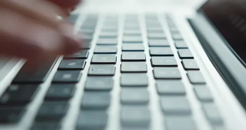 Close up of camera moving behind beautiful female hands typing text on laptop Stock Footage 147049752