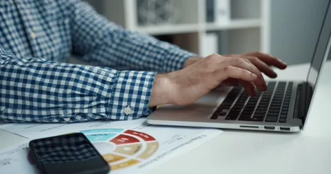 Close up of camera moving behind male hands typing text on laptop keyboard Stock Footage 147051699