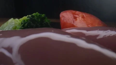 Close-up camera slowly moving between vegetables and raw chicken,water splash Stock Footage 131610177