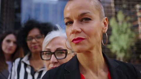 Close-up camera tour of diverse team only business women in line looking serious Stock Footage 316987966