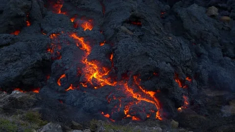 Close up camera view of cooling lava. Hot red magma becoming stone. Fumes around Stock Footage 228805034