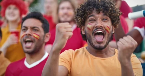 Close camera view of Hispanic friends cheering loudly on stadium. Starting to Video stock 260572719