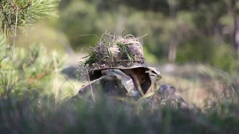 Close-up. Camouflage face paint man watching through binoculars. Ghillie suit Stock Footage 127629281