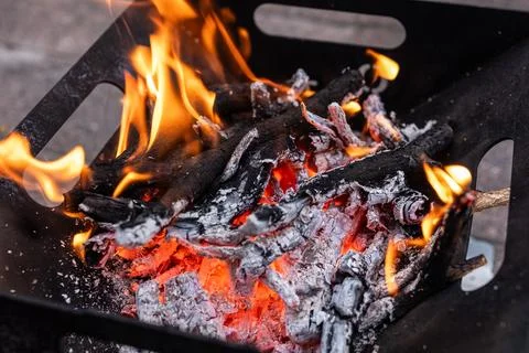 Close up of campfire, fire pit filled with burnt wood, flames. Fire burning.. Stock Photos