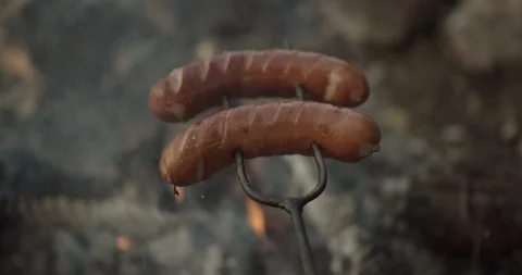 Close up on campfire sausage in the countryside during evening Stock Footage