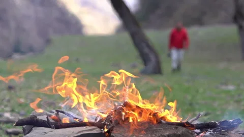Close-Up of Campfire with Tourist Approaching in Background Video stock 303660171