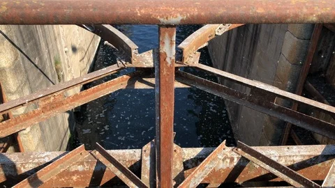 Close up of a canal with a rusty lock and blue water. Stock-Footage 89811666