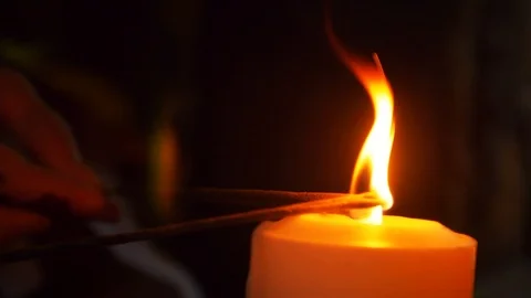 Close-up of a candle about a flame which set incense sticks on fire. Stock Footage 104865671