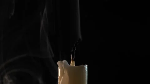 Close-up of a candle on a black background. Candle extinguishing. Stock Footage 225526803
