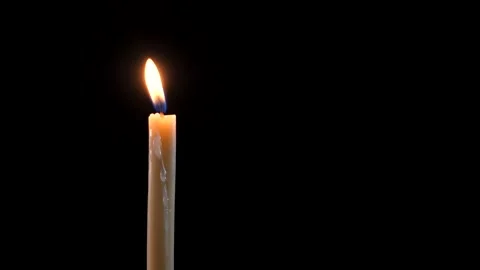 Close-up of a candle on a black background. Long burning candle. Stock Footage 225526915