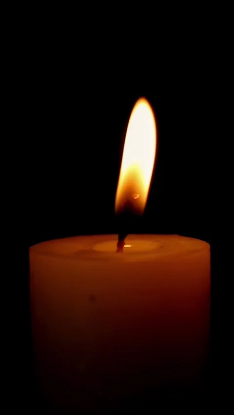 Close candle flame swaying gently in dark background Stock Footage 323966121