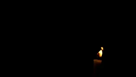 Close up of candle flame swaying in the wind isolated black background Stock Footage 294948158