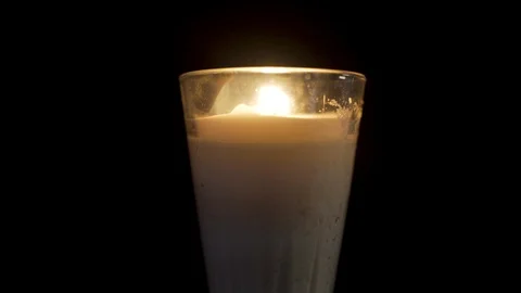 Close up of a candle lighting off in a black background Stock Footage 96454470
