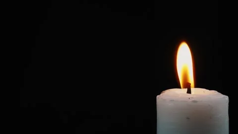 Close up of candle lit in corner isolated black background Stock Footage 279039867