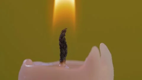 Close-up of candle wick ignited with match isolated on yellow background Stock Footage 144627166