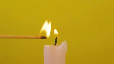 Close-up of candle wick ignited with splinter isolated on yellow background Stock Footage 144554468