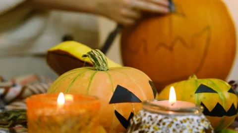 Close-up. Candles are burning. The camera focuses on the one-eyed pumpkin. Stock Footage 219258237