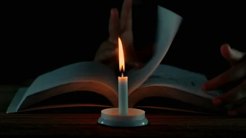 Close up candles flame hands young woman open the book on old table. Stock Footage 151490751