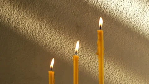 Close up candles flame on sunrise drop shadow old concrete wall. Stock Footage 151870368