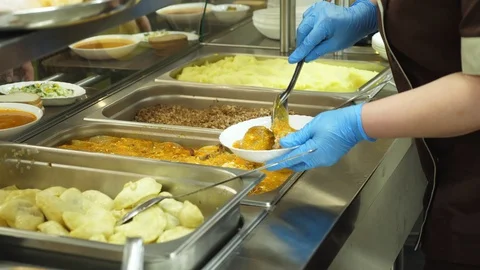 Close-up, canteen worker lays a portion of meat patties on the plate. in modern Stock-Footage 103579884