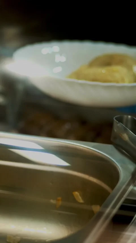Close-up, canteen worker lays a portion of dumplings on the plate. in modern Stock Footage 322512651