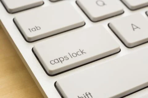 Close up caps lock button on white keyboard. Stock Photos