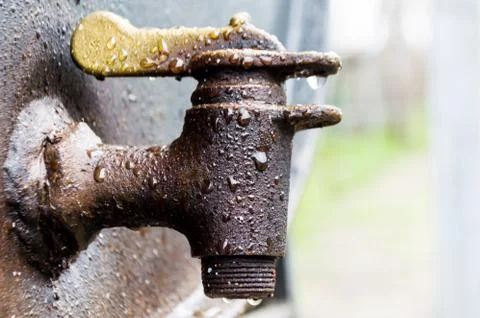Close capture on rain drops on a rusted faucet Stock Photos