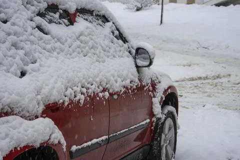 Close-up of a car covered in a thick layer of snow during a snowstorm Stock Photos