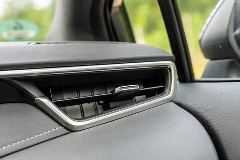 Close up of a car dashboard air vent with chrome trim and stitched leather Fotos Stock