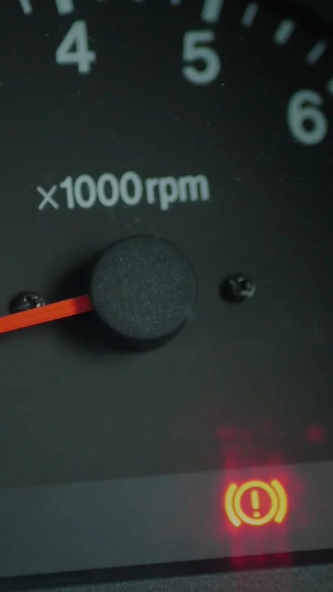 Close-up of car dashboard showing an illuminated red brake... Stock Footage 344455313