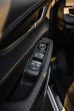 Close-up of car door panel featuring control buttons for windows and mirror.. Stock Photos