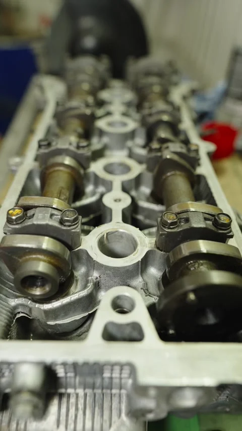 Close-up of a car engine cylinder head with camshafts on a workbench Stock Footage 340334810