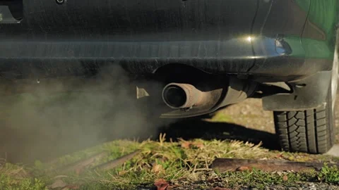 Close-up of a car exhaust pipe with traces of rust, emitting poisonous coal gas Stock Footage 296088880