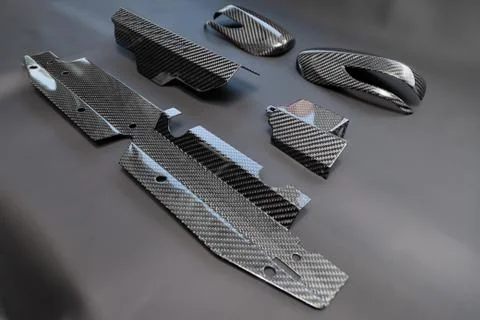 A close-up on a car exterior elements made from carbon fiber of interwoven bl Stock Photos